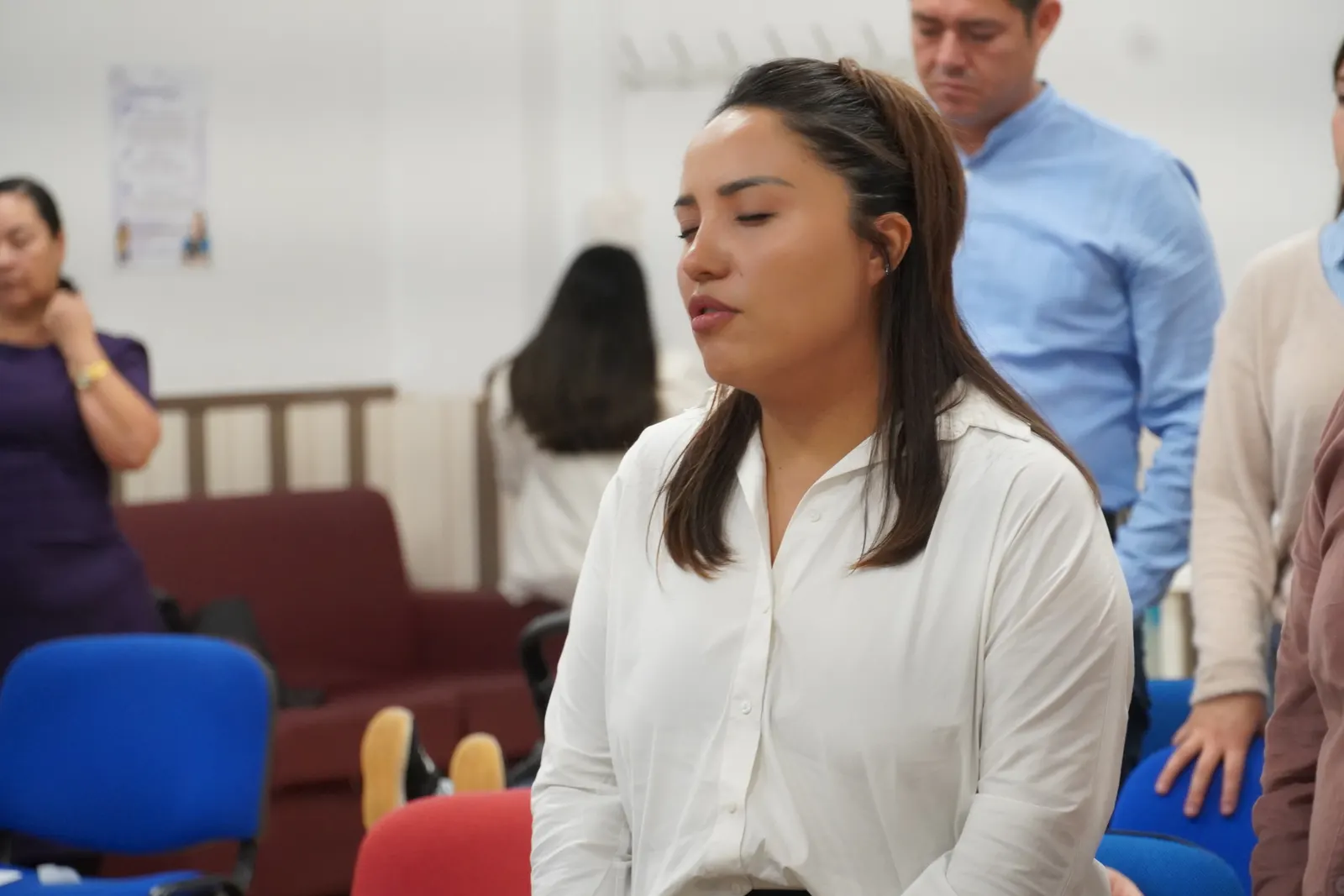 Una hermana canta con los ojos cerrados durante la alabanza