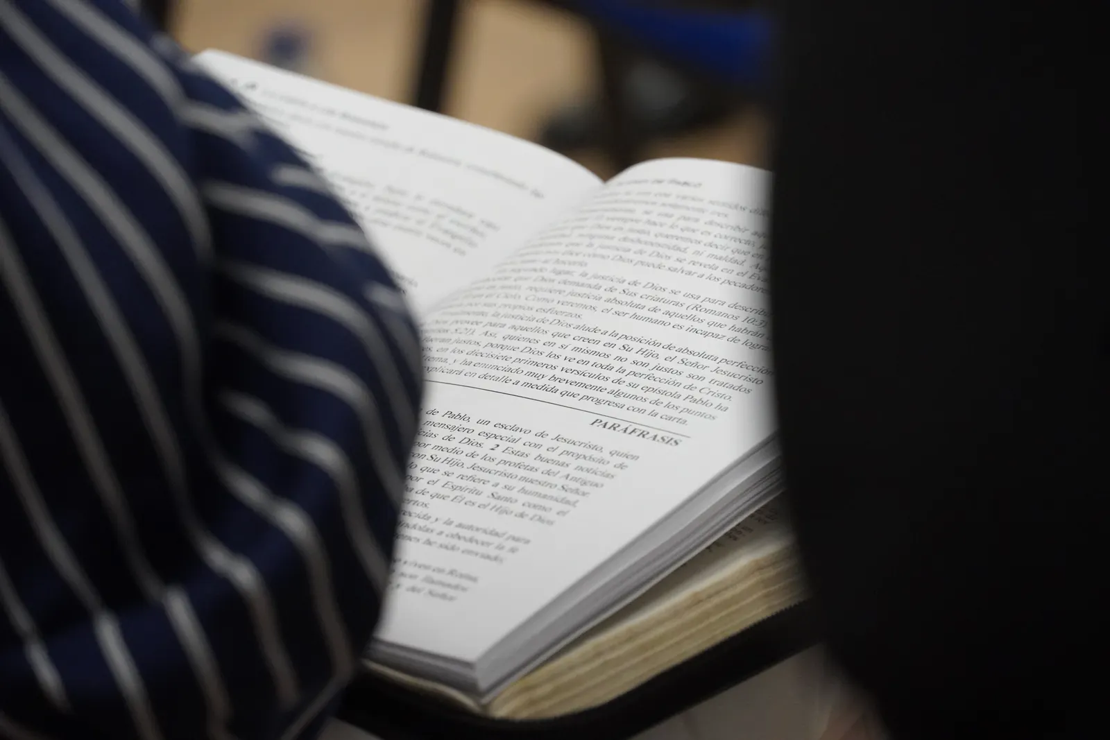Una Biblia abierta entre las manos de una persona