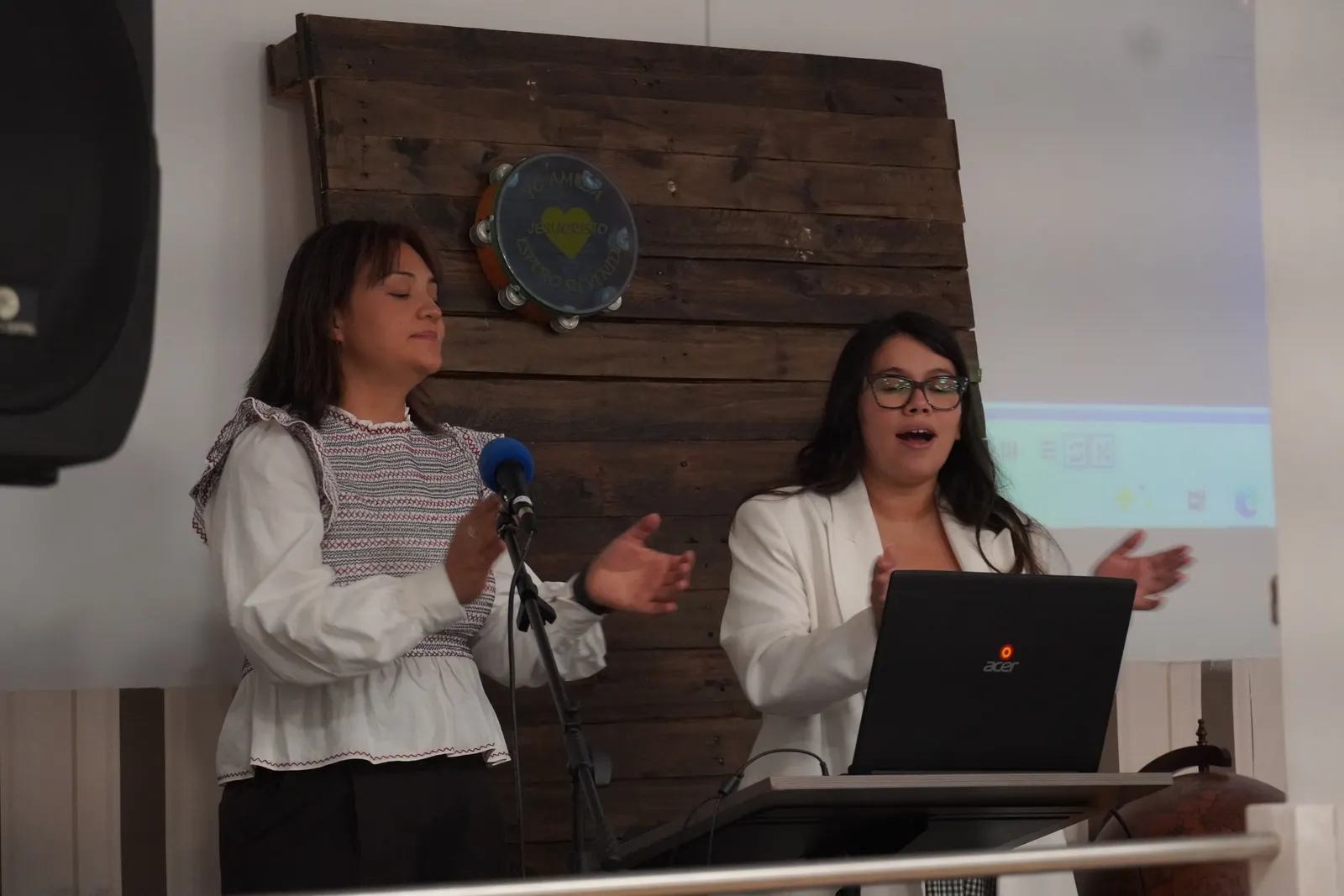 Dos hermanas dirigen la alabanza con el micrófono
