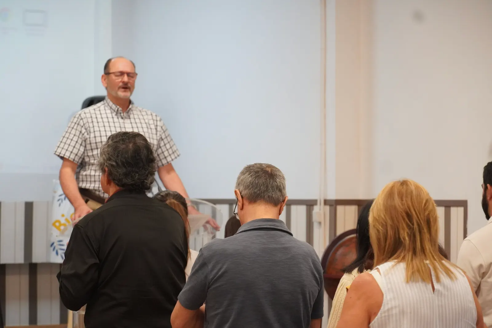 Una hermana predica mientras la congregación escucha